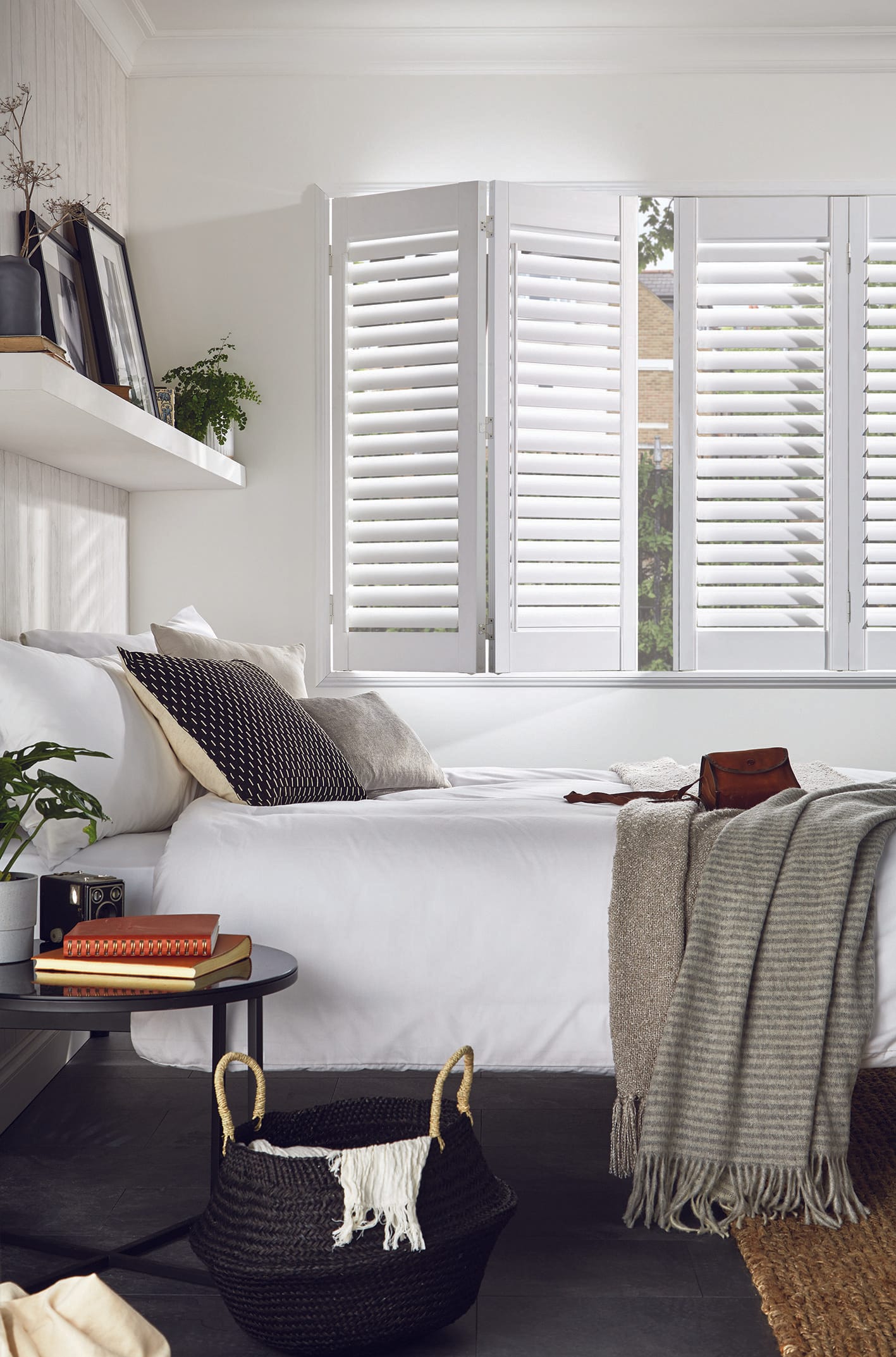 Full-height bi-fold plantation shutters in a bedroom