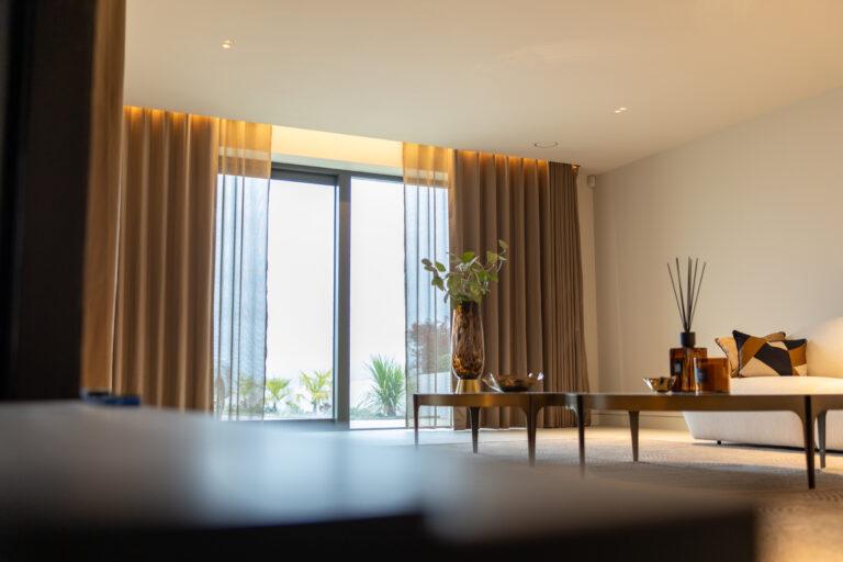 Floor-length bronze curtains with sheer panels framing tall glass doors in a bright living room
